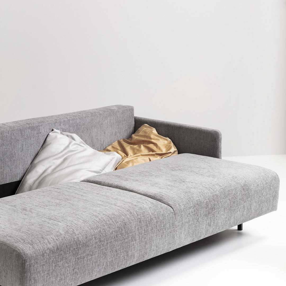 Hovden Flexy sovesofa i grå, nærbilde av sete med pute og svarte ben