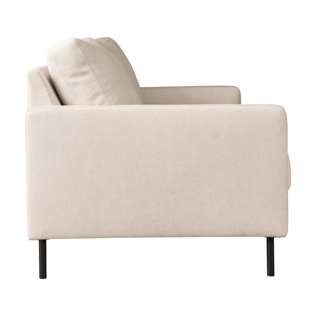 Hovden Como 3-seter sofa i kremhvit stoff med sorte metallben, sett skrått fra siden