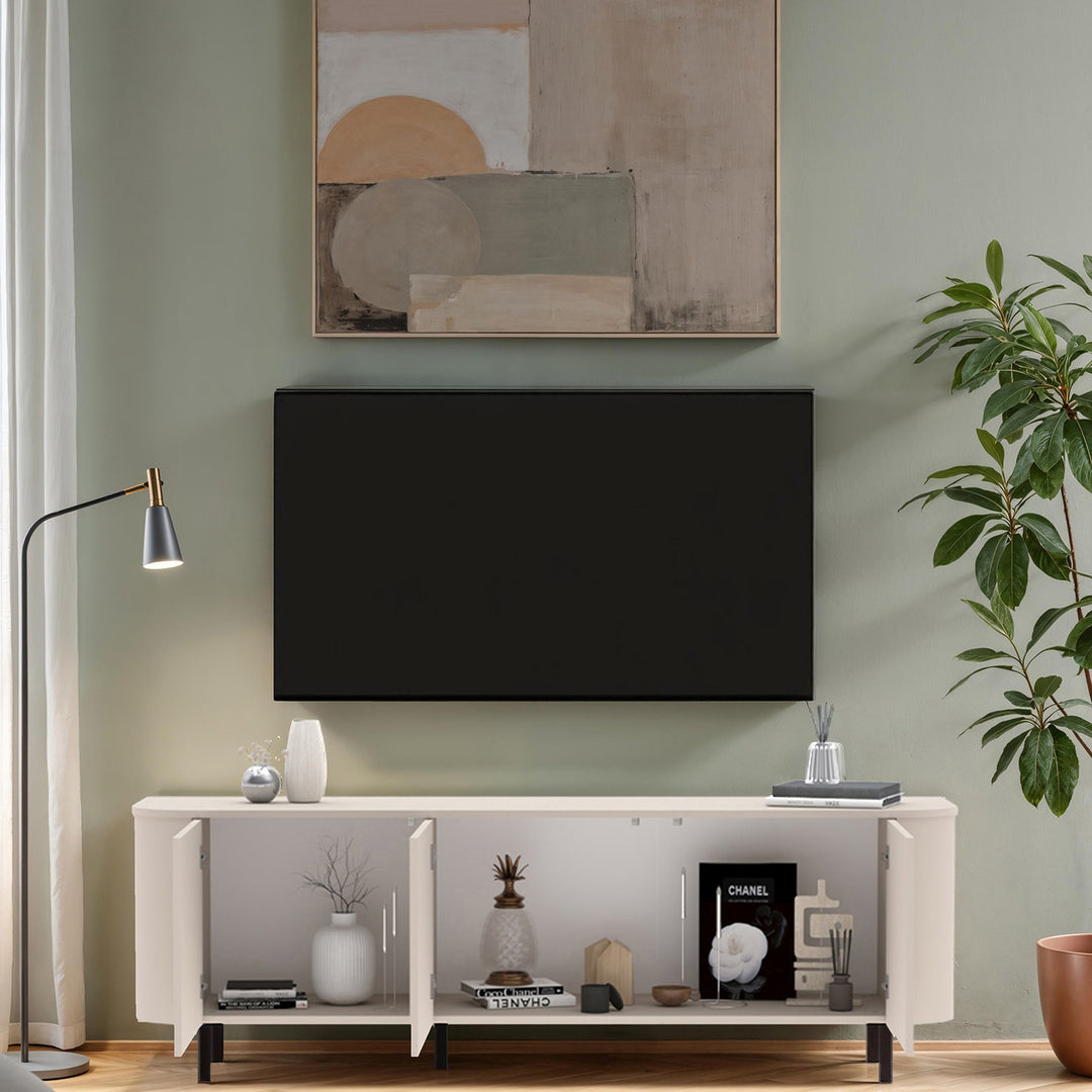 Lido tv-benk i sand med åpne dører og styling i salviegrønn stue med plante og gulvlampe