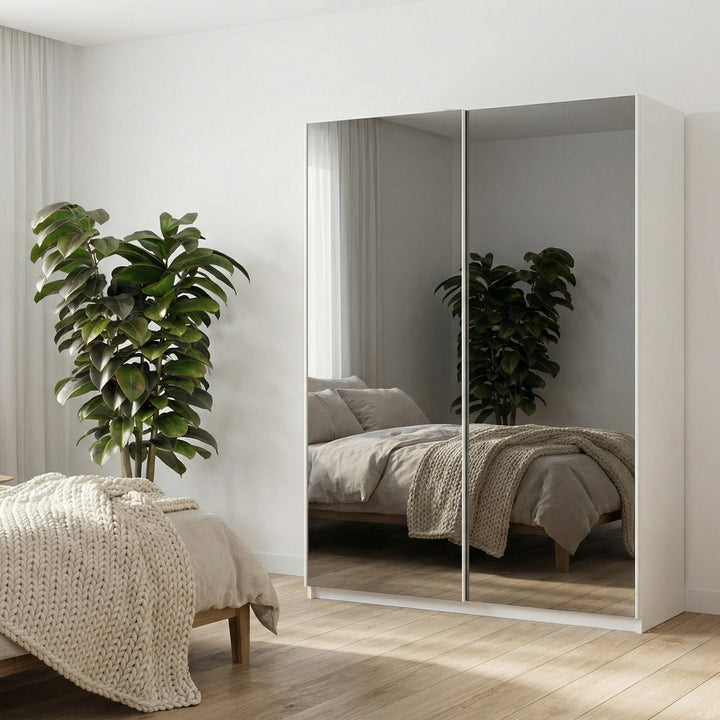 Swing garderobeskap i hvitt med speildører i lyst soverom med grønn plante ved beige seng.