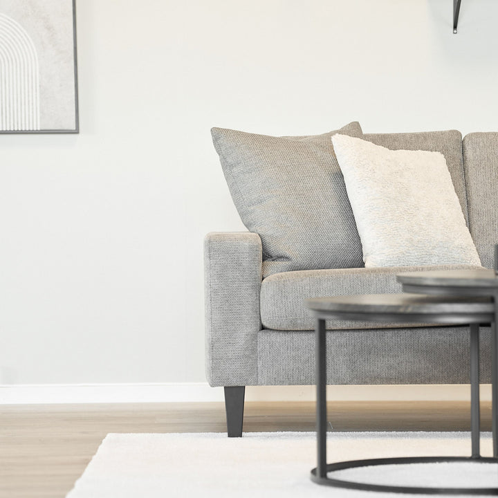 Lone Sensation teppe i cremehvitt foran grå sofa med sorte sofabord.