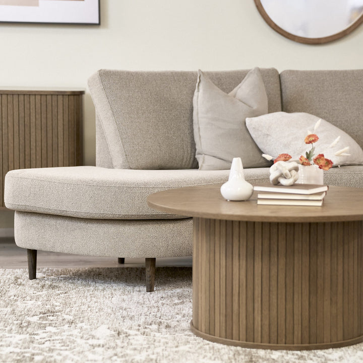 Lone Porto teppe i beige under bouclésofa og rundt rillet trebord i lys stue