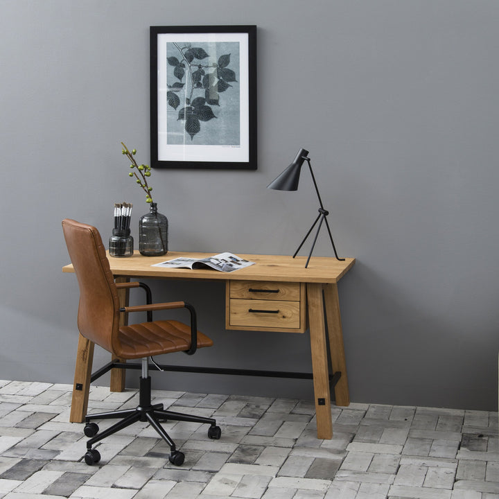 Winslow kontorstol i cognac kunstskinn ved eikeskrivebord mot grå vegg med plakat og lampe
