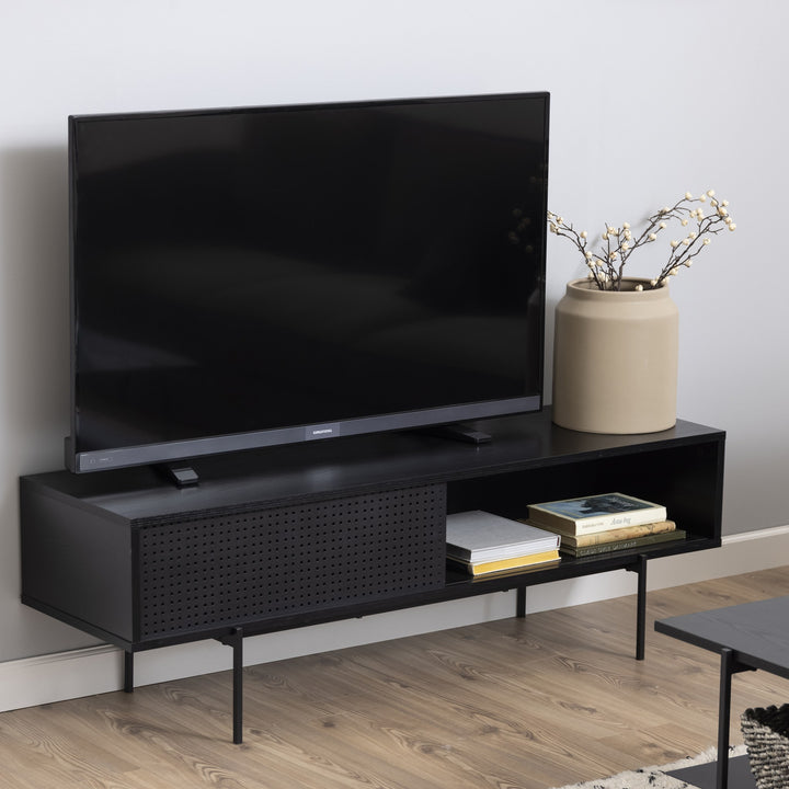 Angus TV-benk i sort med perforert dør, TV og beige vase med kvister