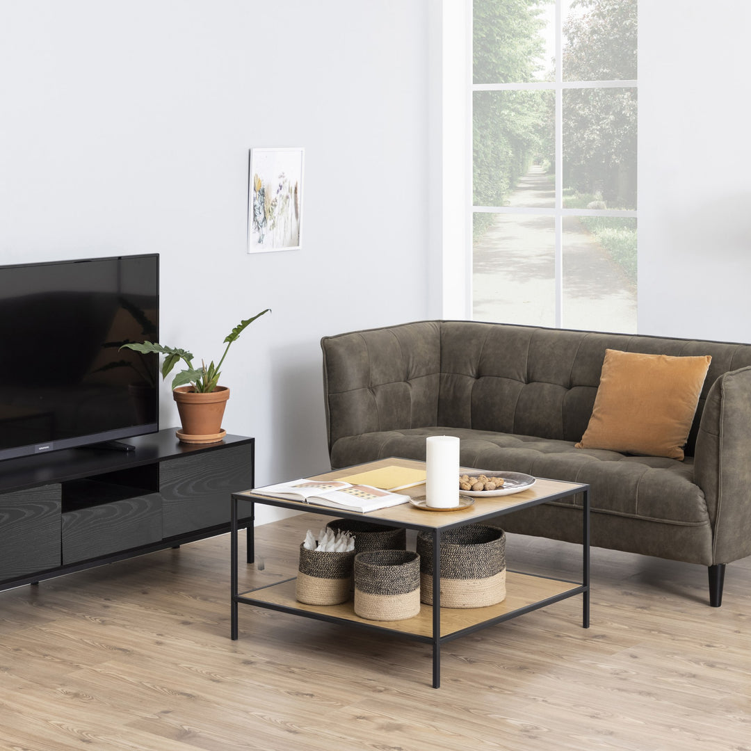 Seaford TV-benk i sort med TV og grønnplante i lys stue med grønn sofa og sofabord