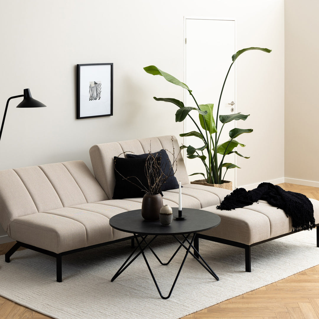 Caix sovesofa i beige stoff utslått flatt som dobbeltseng, sett skrått