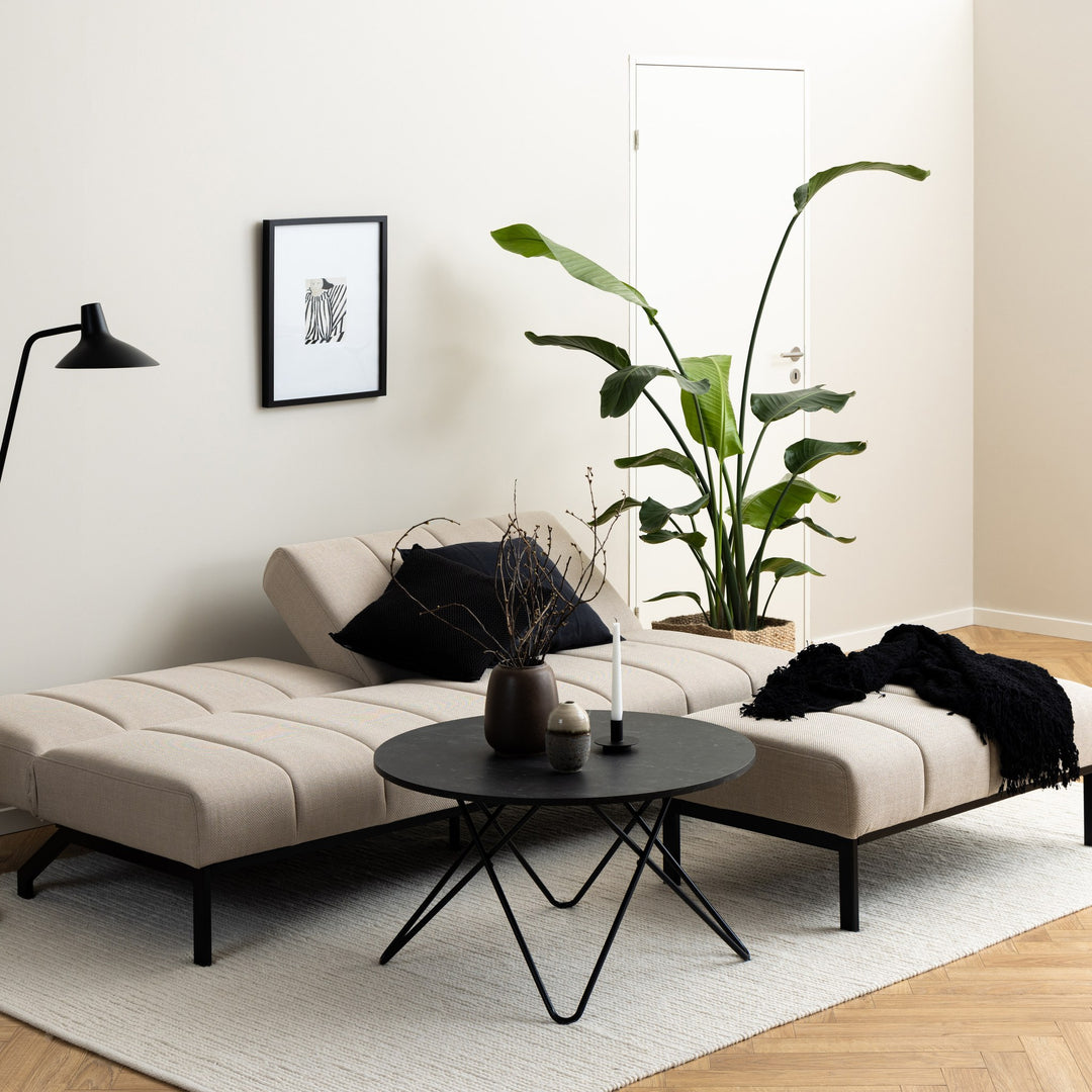 Caix sovesofa sett bakfra, beige sete med svart bakside og metallramme