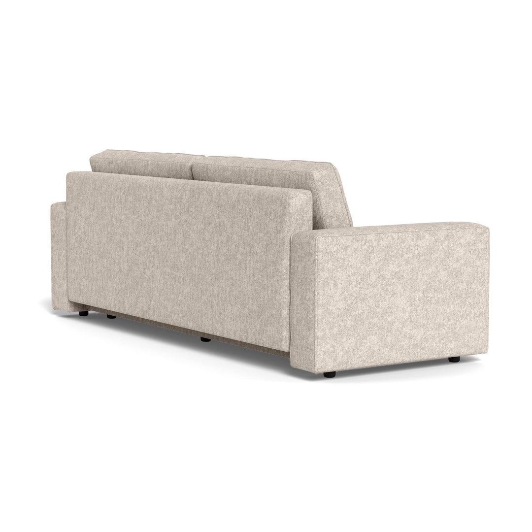 Vento sovesofa i beige chenille sett skrått bakfra, med brede armlener