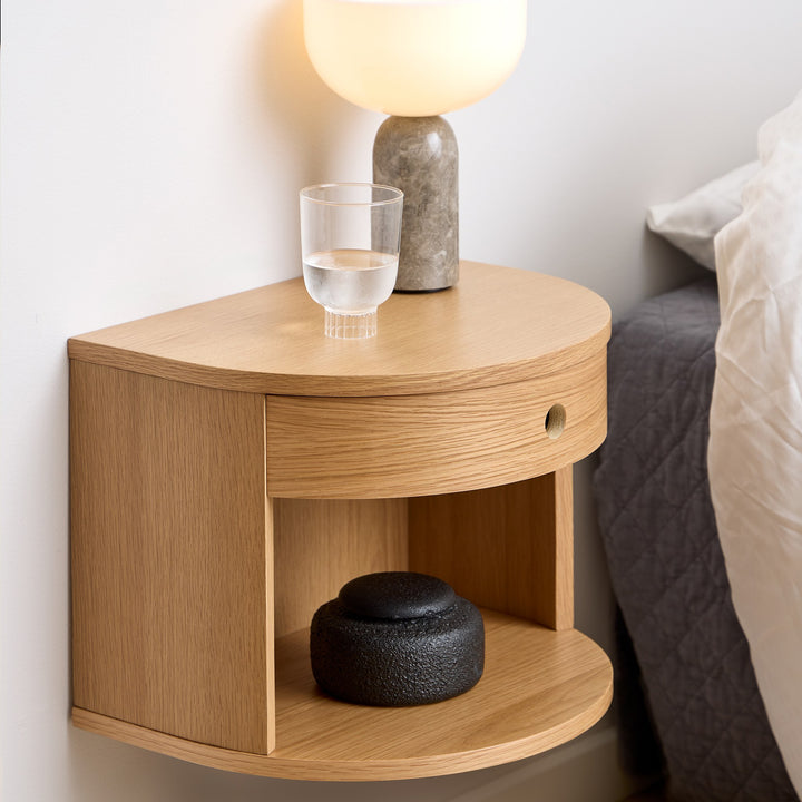 Paron nattbord i matt eik med rund front og hylle, vegghengt ved seng med marmorlampe