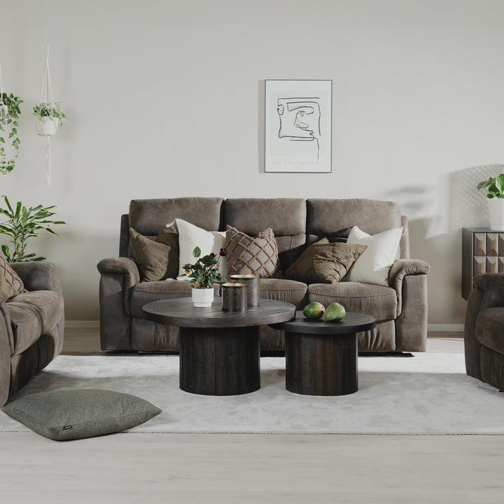 Mayfield sofa i brunt stoff med matchende lenestoler i lys stue med runde trebord og planter