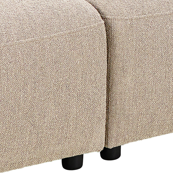 Rushville hjørnesofa i beige bouclé, nærbilde av seteskjøt og sorte ben