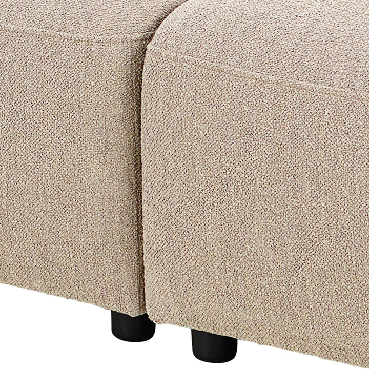 Rushville hjørnesofa i beige bouclé, nærbilde av åpent venstrehjørne med sorte ben