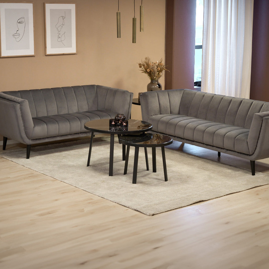 Tampa sofa i grå velur med kannelert rygg i varm stue med sorte marmorbord og tørket pampas