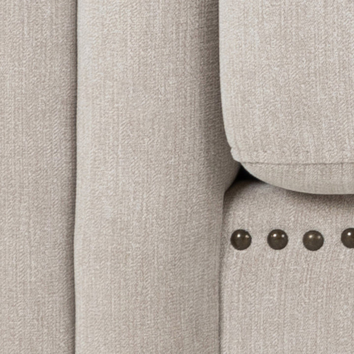 Charlietown sofa, nærbilde av beige linstoff med naglebånd langs kanten.
