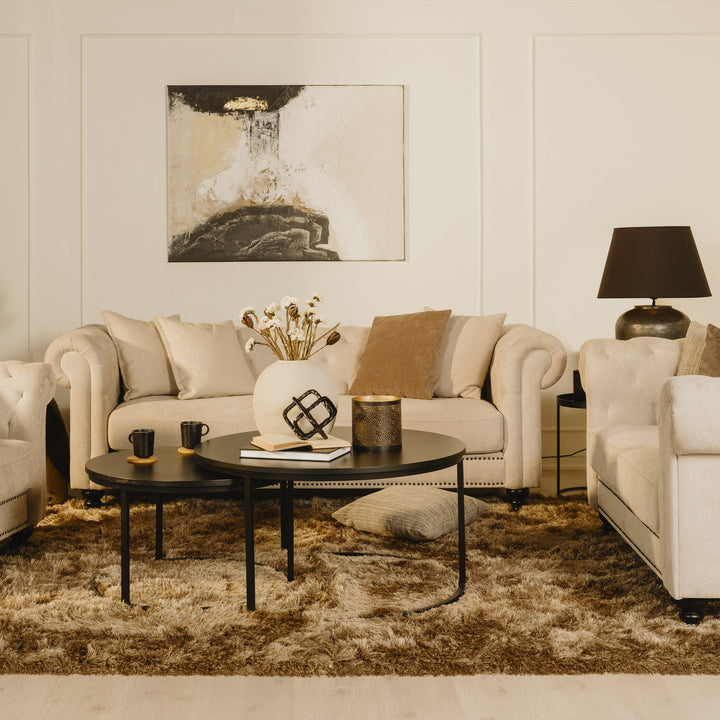 Charlietown sofa i beige linstoff i stue med brunt teppe og svart bordlampe.