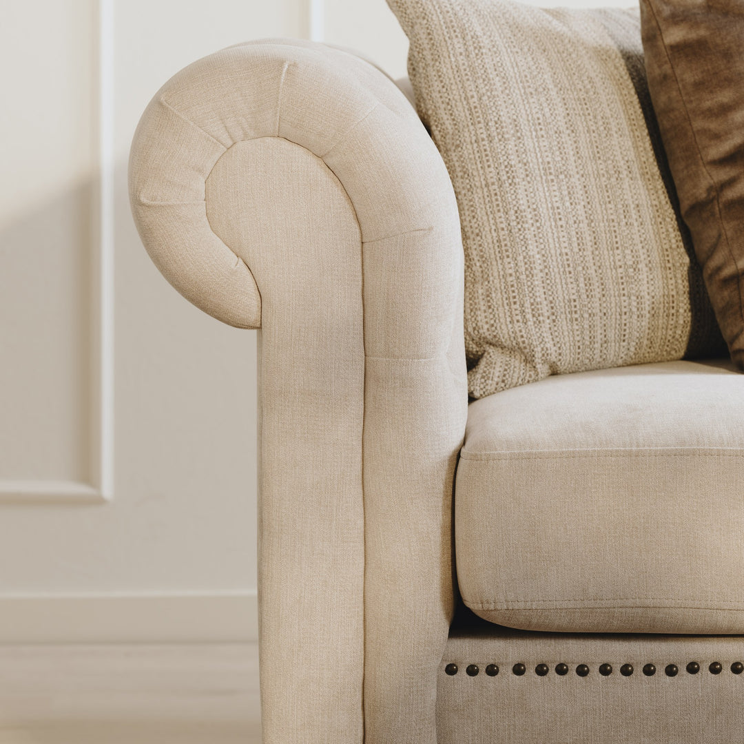 Charlietown sofa, nærbilde av rullet armlene i beige linstoff med pyntepute.