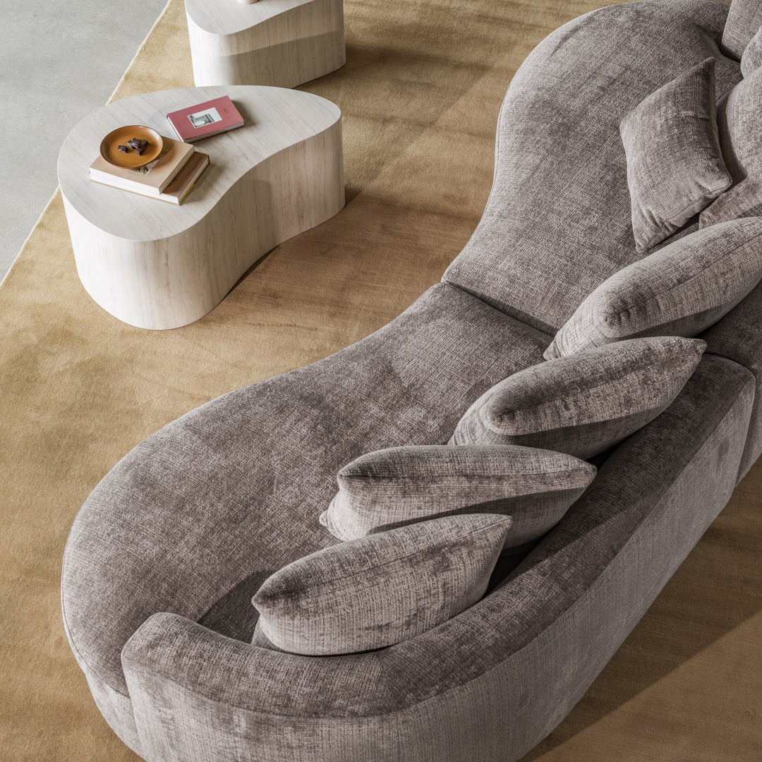 Cordova sofa i gråbrun chenille sett ovenfra, med puterekke og nyreformet sidebord i tre.