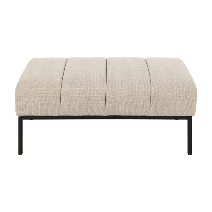 Caix puff i beige stoff med sorte metallben, sett forfra