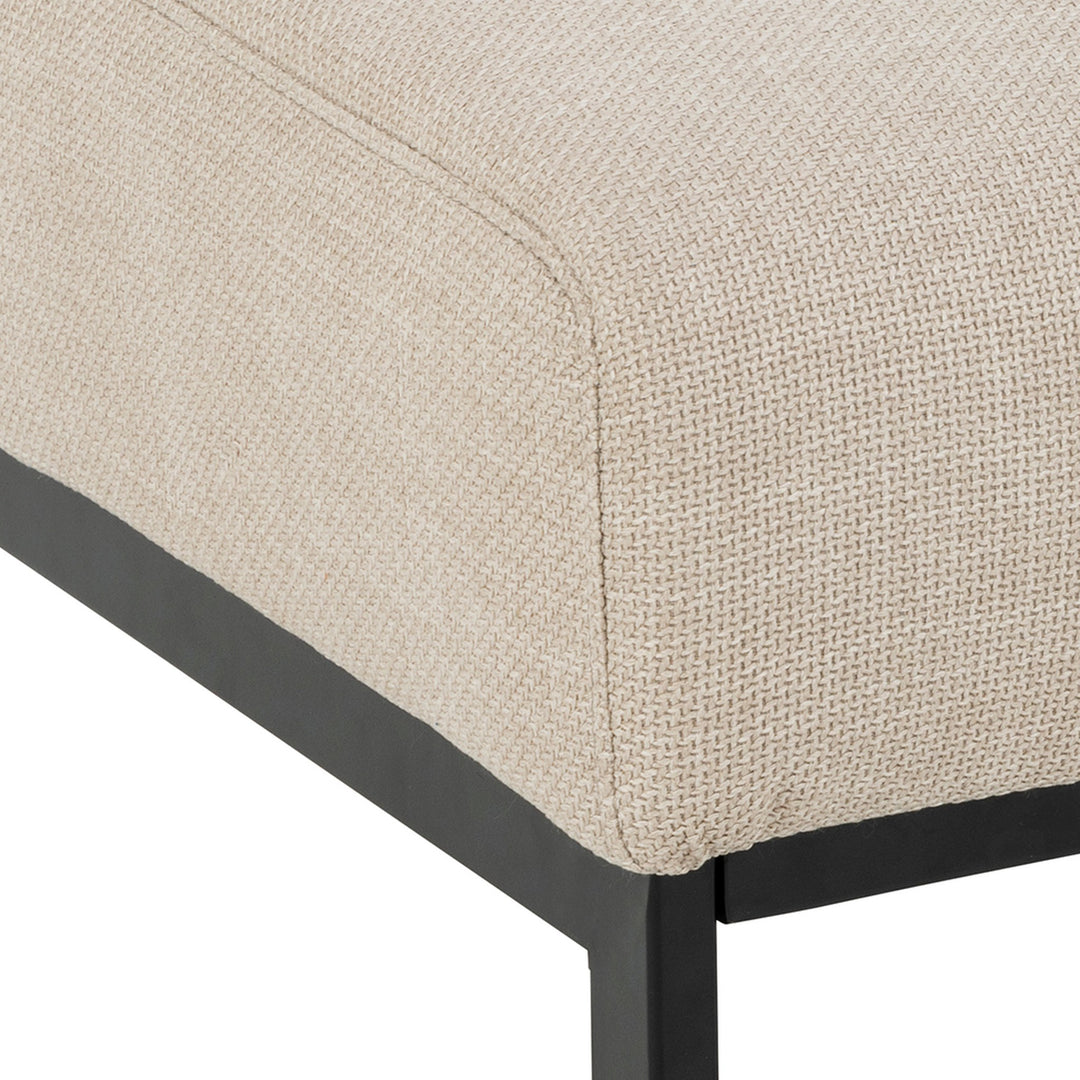 Caix puff i beige stoff, nærbilde av hjørne med sort metallramme