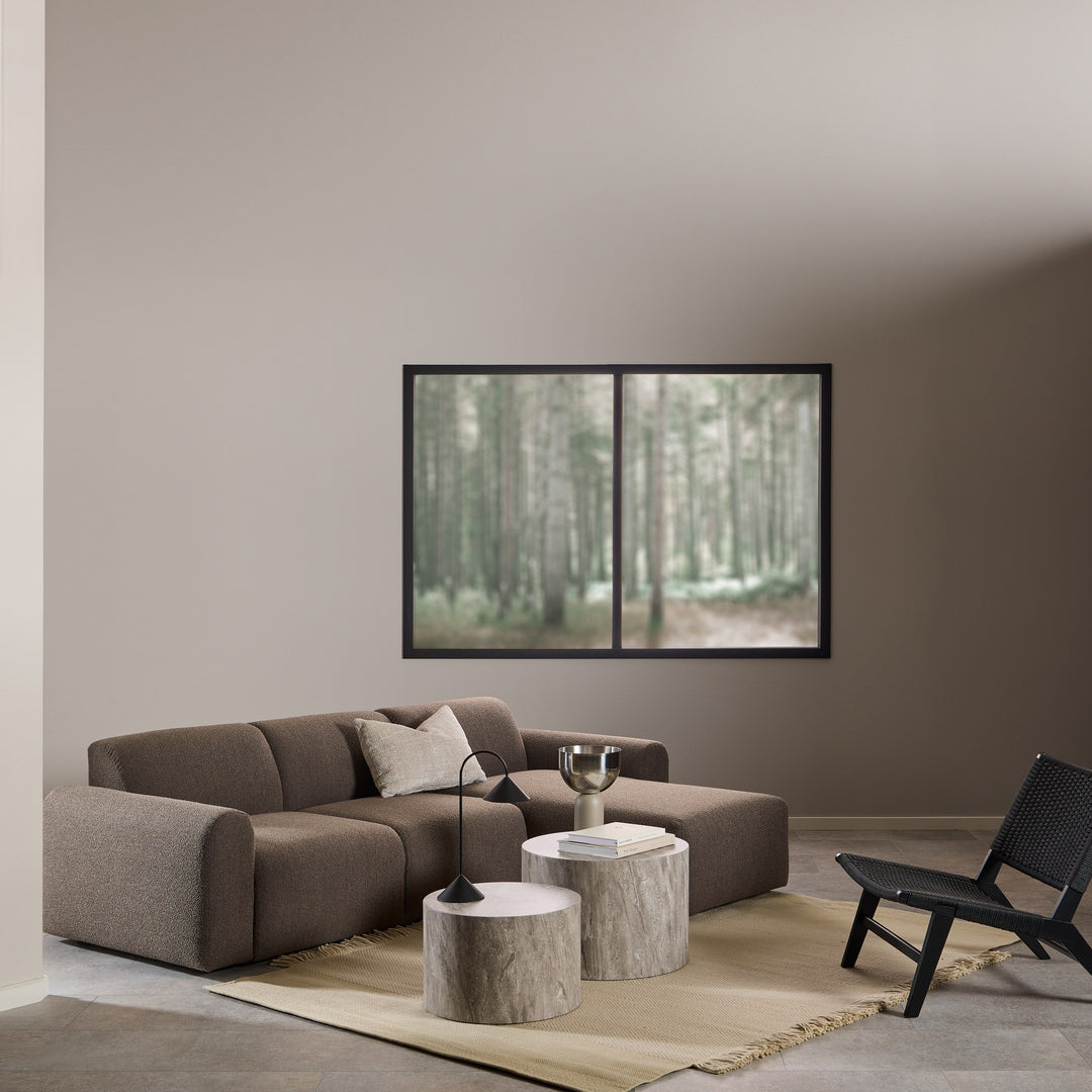 Carson stol i sort flettverk i stue med brun sofa og skogmotiv på vegg