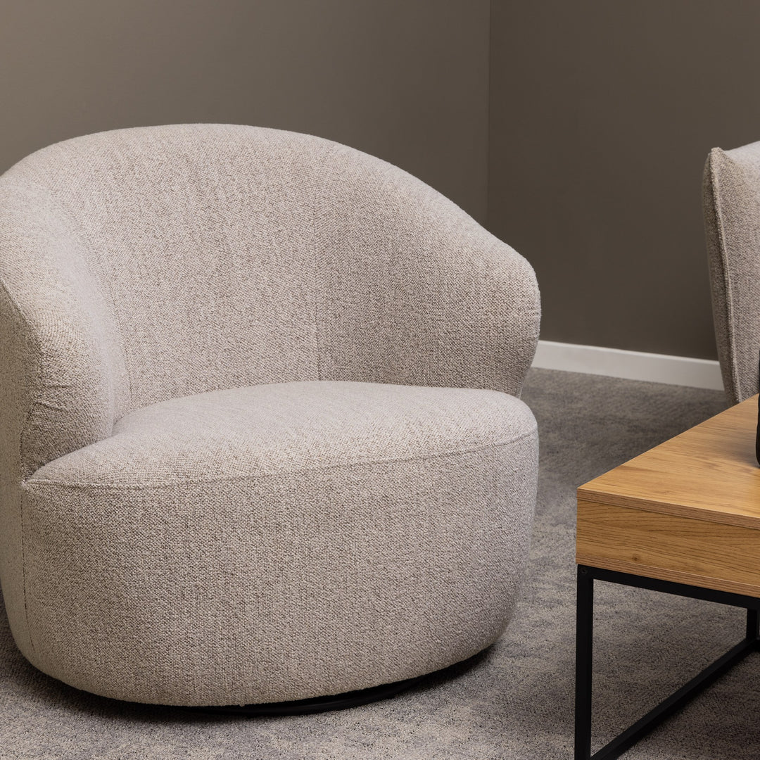 Westport loungestol i lys beige bouclé, rund modell i stue med grått teppe og eikebord