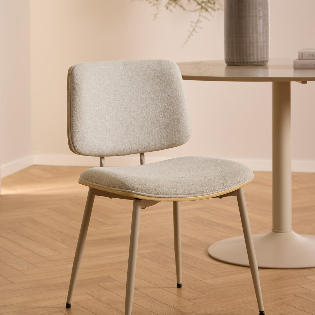 Ibiza spisebord i beige, rundt bord med beige stol på fiskebensparkett, vase og bøker