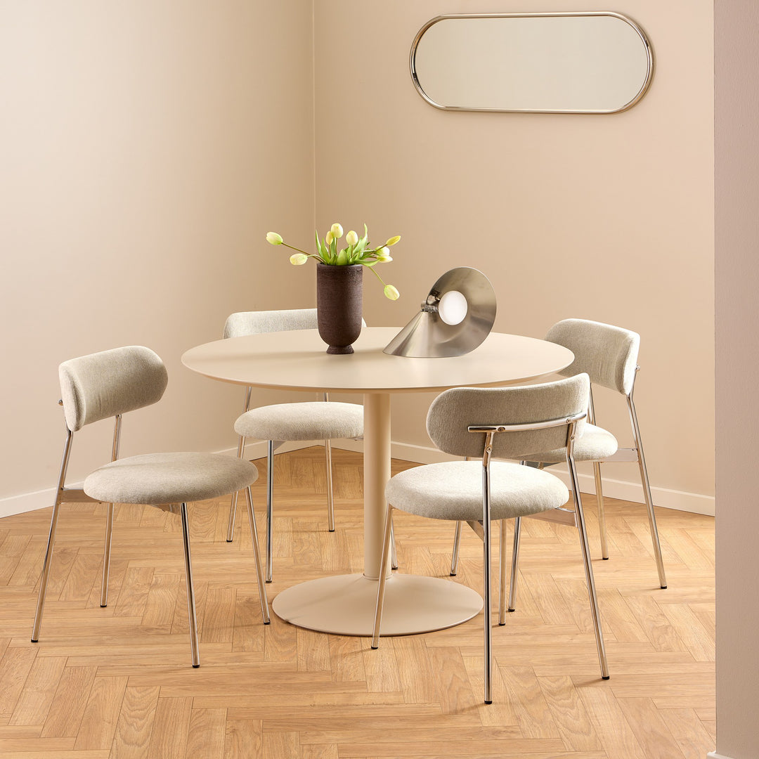 Ibiza spisebord i beige med rund plate og søylefot, lyse boucléstoler, tulipaner i vase og parkettgulv.