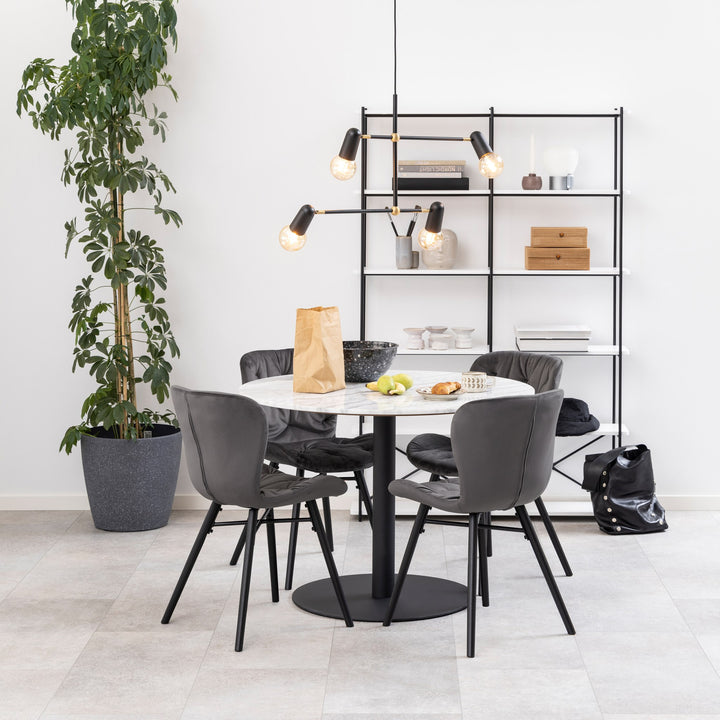 Corby spisebord med hvit marmorplate og sort fot, med grå stoler, plante og reol i lyst rom