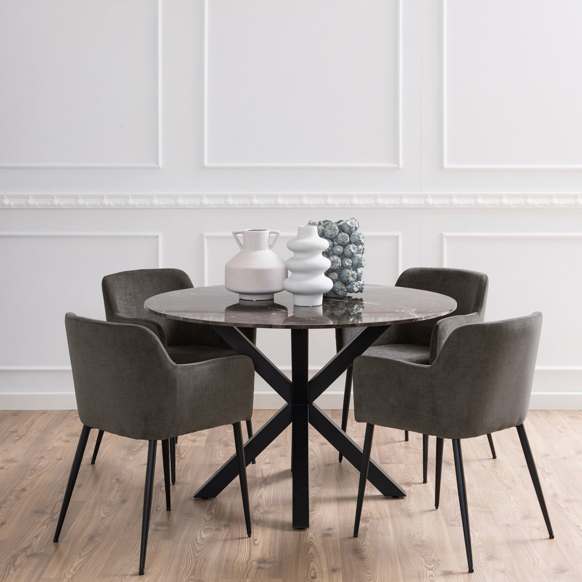 Earth spisebord med brun marmorplate og sort kryssfot, med gråbrune stoler mot hvit panelvegg