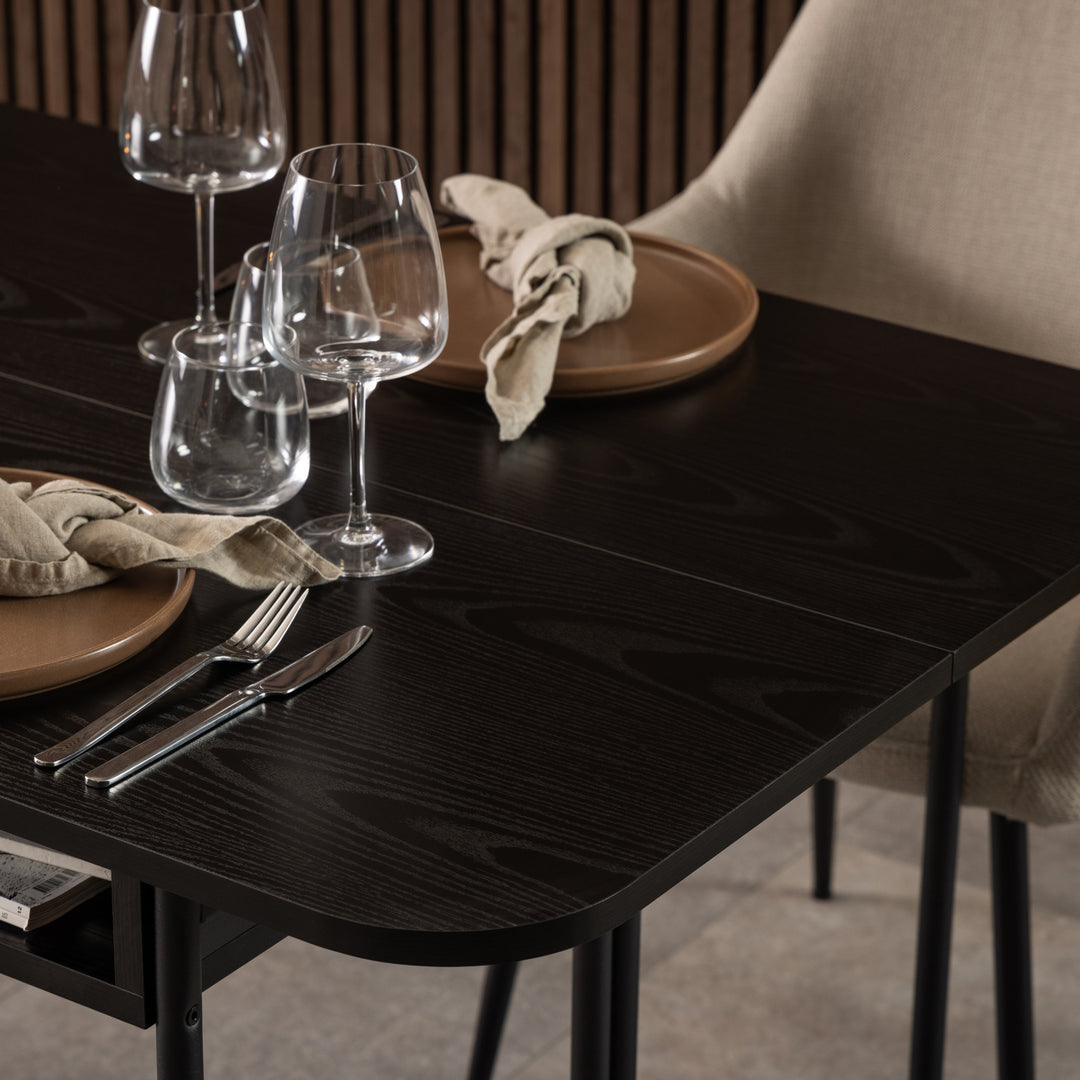 Darlington spisebord i sort med dekket kuvert, vinglass og beige stol mot panelvegg