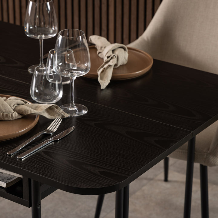Darlington spisebord i sort med dekket kuvert, vinglass og beige stol mot panelvegg