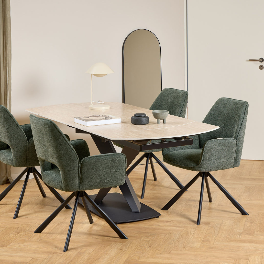 Morella spisebord med oval beige steinplate og svart ben, omgitt av mørkegrønne stoler på fiskebensparkett
