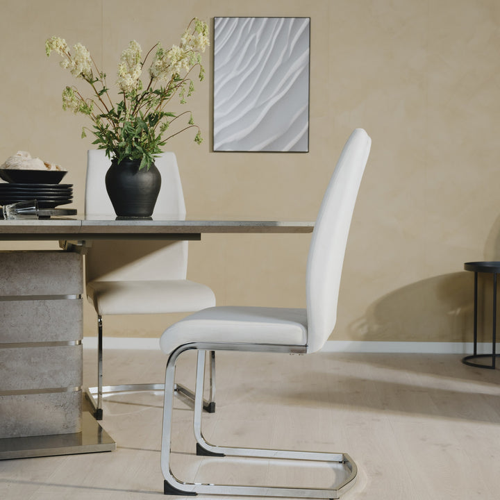 Ulla spisestol i sandfarget velur med forkrommet meiebein, stylet ved steinbord og blomster