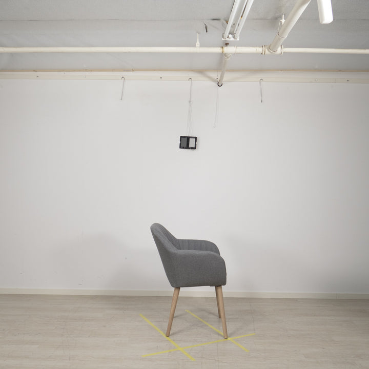 Emilia spisestol i lys grå stoff med ben i tre, sett fra siden i lyst studio