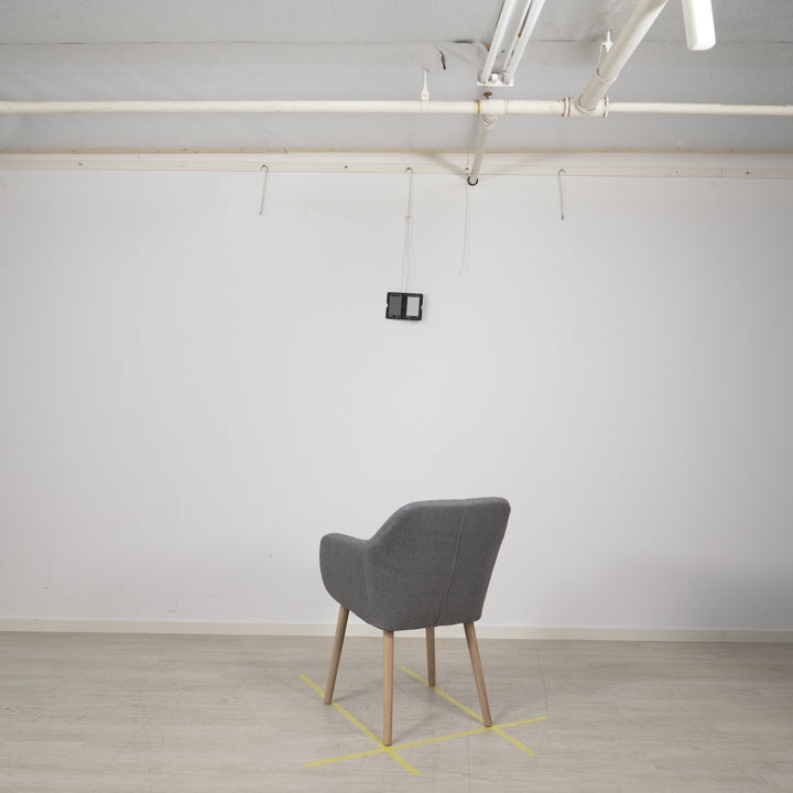 Emilia spisestol i lys grå stoff med ben i tre, sett bakfra i lyst studio