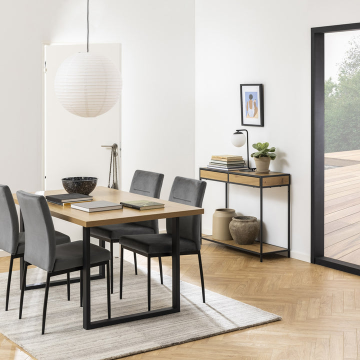 Demi spisestoler i grå fløyel ved et lyst eikebord i moderne spiserom med parkett og papirlampe