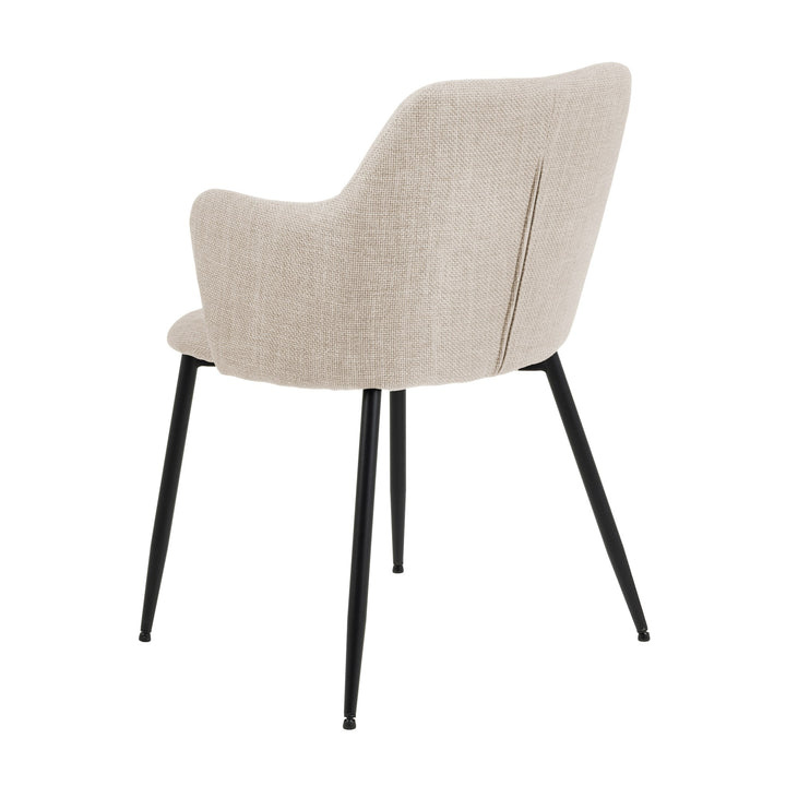 Ilsa spisestol i beige tekstil med armlener og svarte ben, sett skrått bakfra