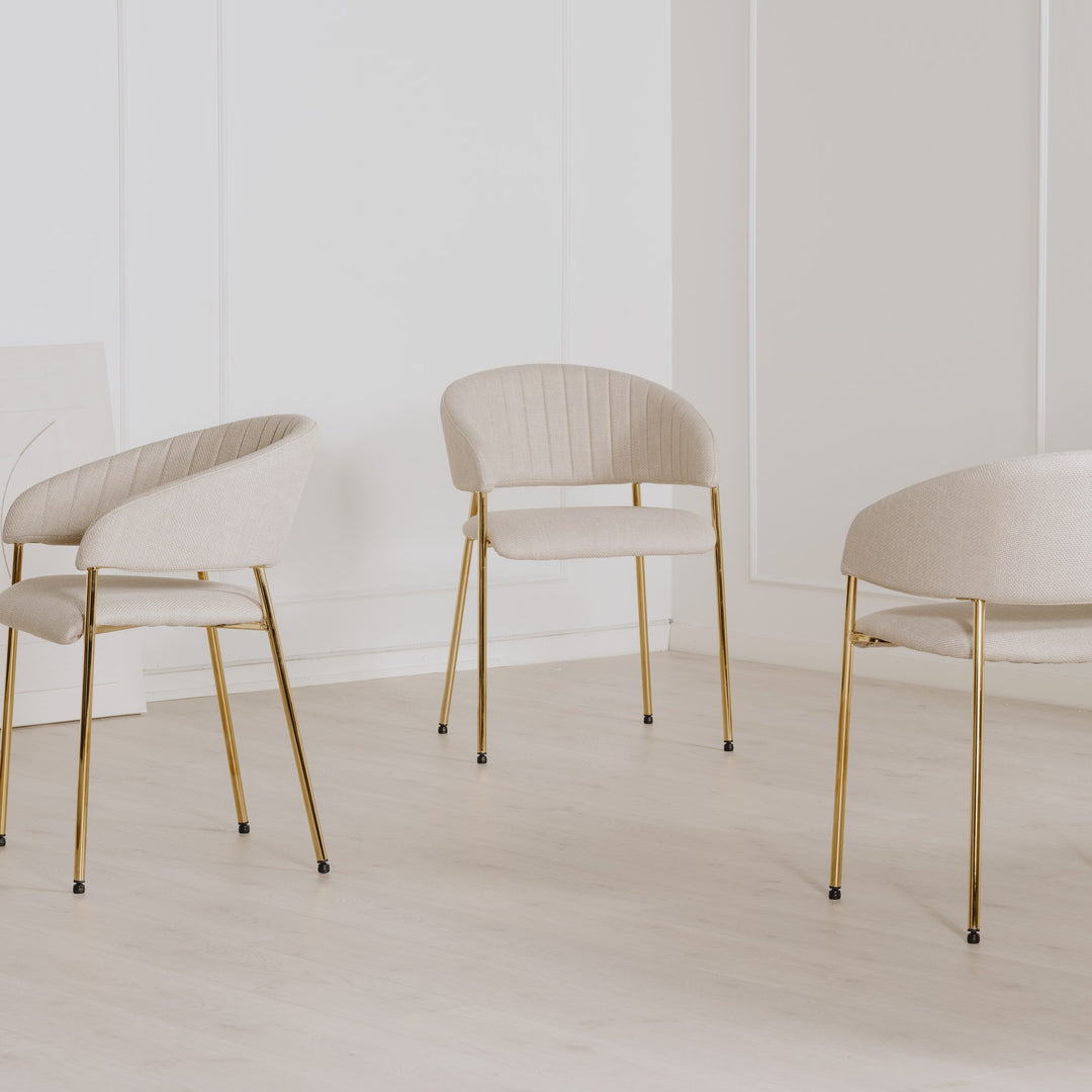 Ann spisestol i beige med gullben, tre stoler i lyst rom med panelvegg