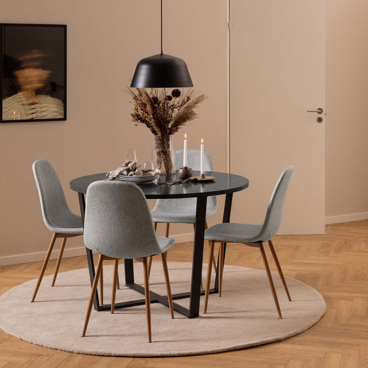 Celia spisestoler i lys grå rundt sort spisebord med tørkede blomster, beige teppe og sort taklampe