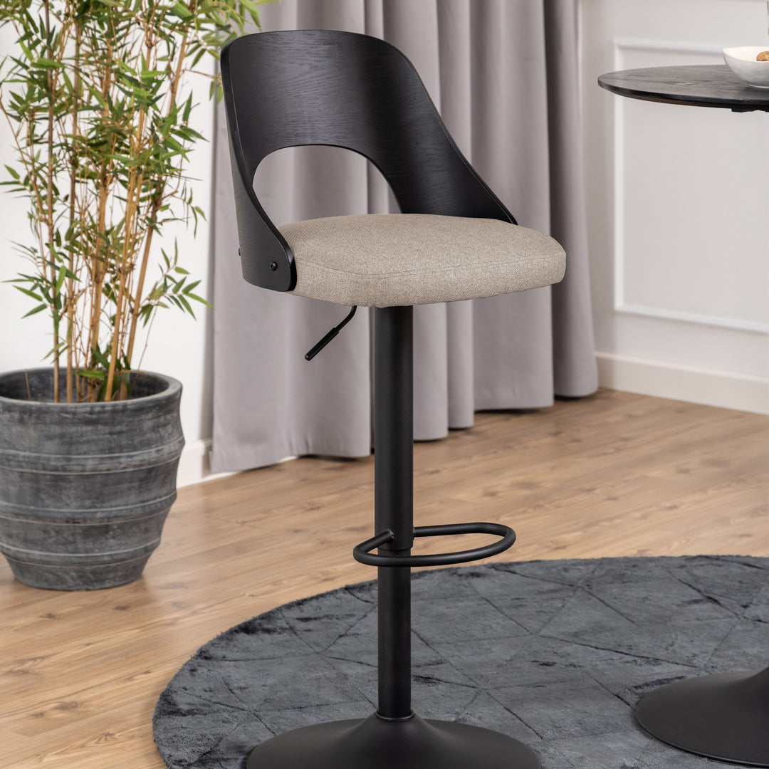 Lucy barstol med sort treramme og beige sete, ved bambusplante og grå gardin