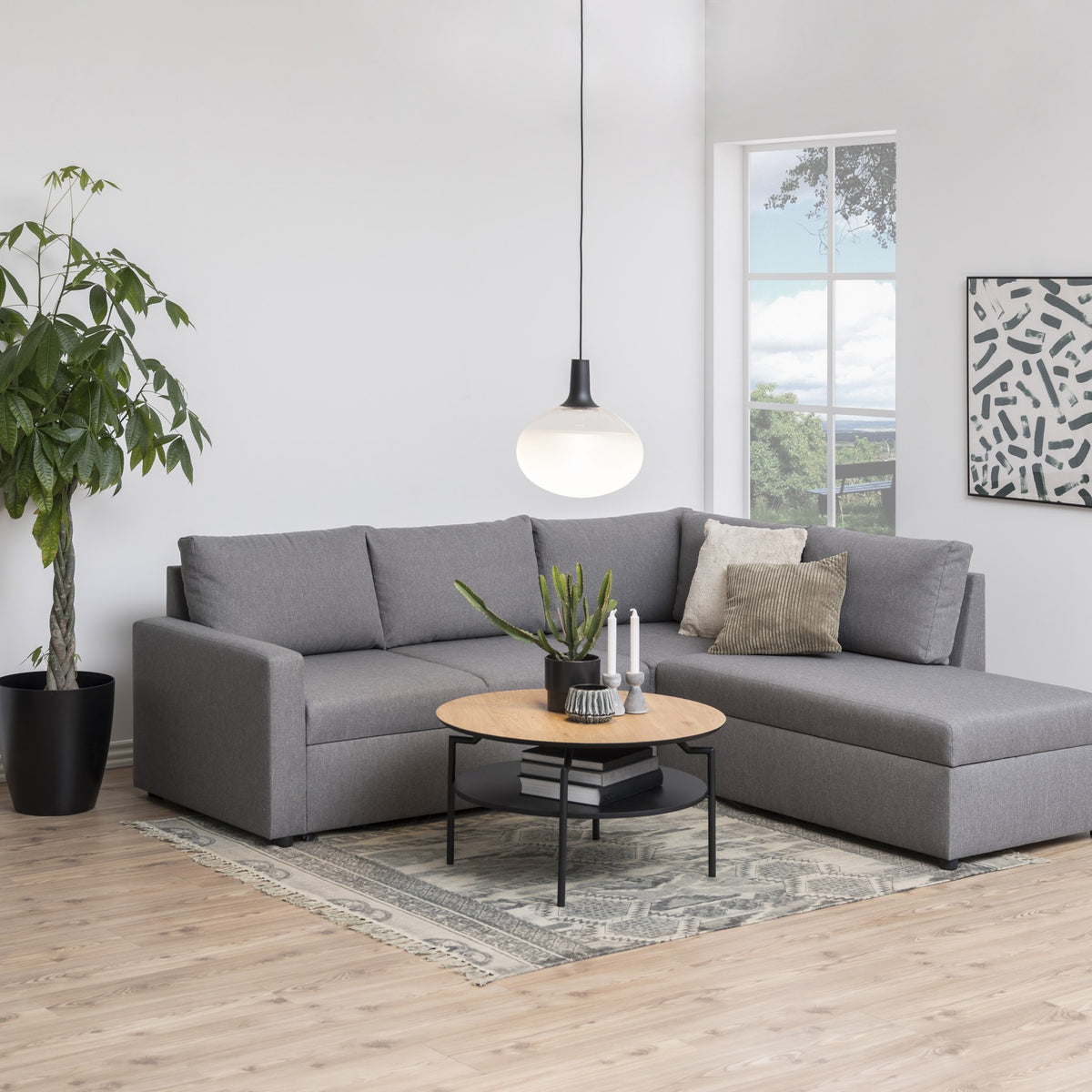 Goldington sofabord i lys eikeimitasjon med hylle, foran grå sofa med plante