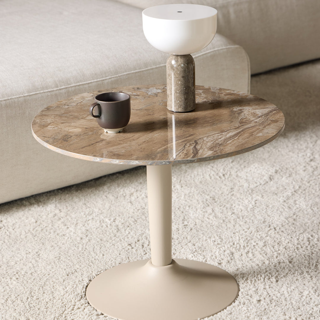 Malta sofabord med brun marmorert plate og sandfarget fot foran lys sofa