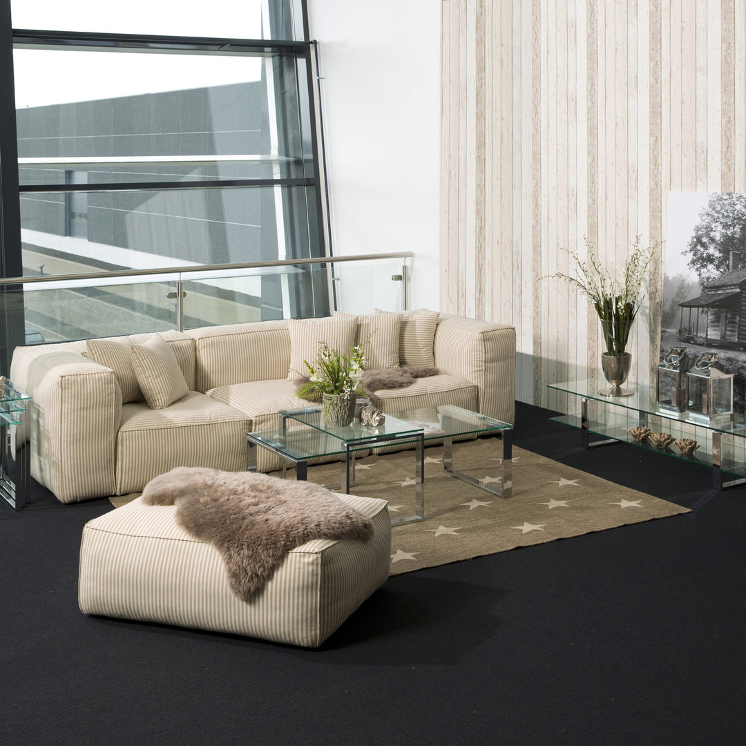Katrine sofabord i klart glass og krom, i lys stue med beige sofa og stjerneteppe