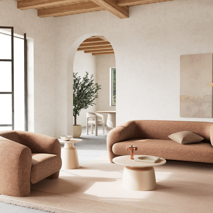 Santorini sofabord med travertinplate og beige fot, i lyst rom med terrakotta sofaer og oliventre.