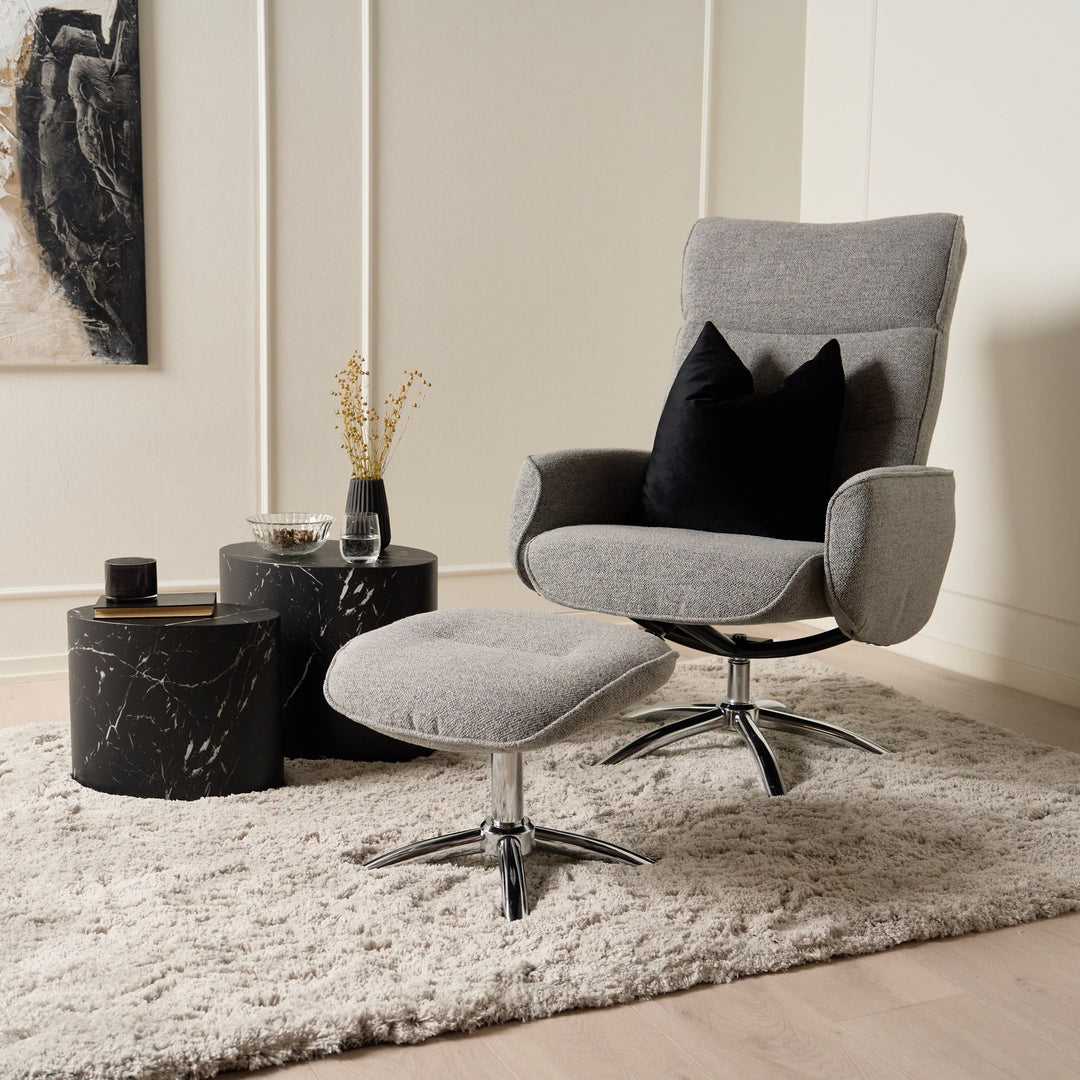 Mice sidebord i sort marmor, to runde bord ved grå lenestol med fotskammel