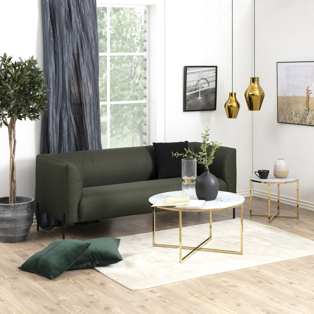 Alisma sidebord med marmorglass og gullramme ved mørk grønn sofa og rund marmorbord