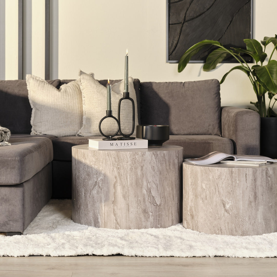 Dice sidebord i grå marmorlook foran gråbrun sofa med grønn plante og sort kunst