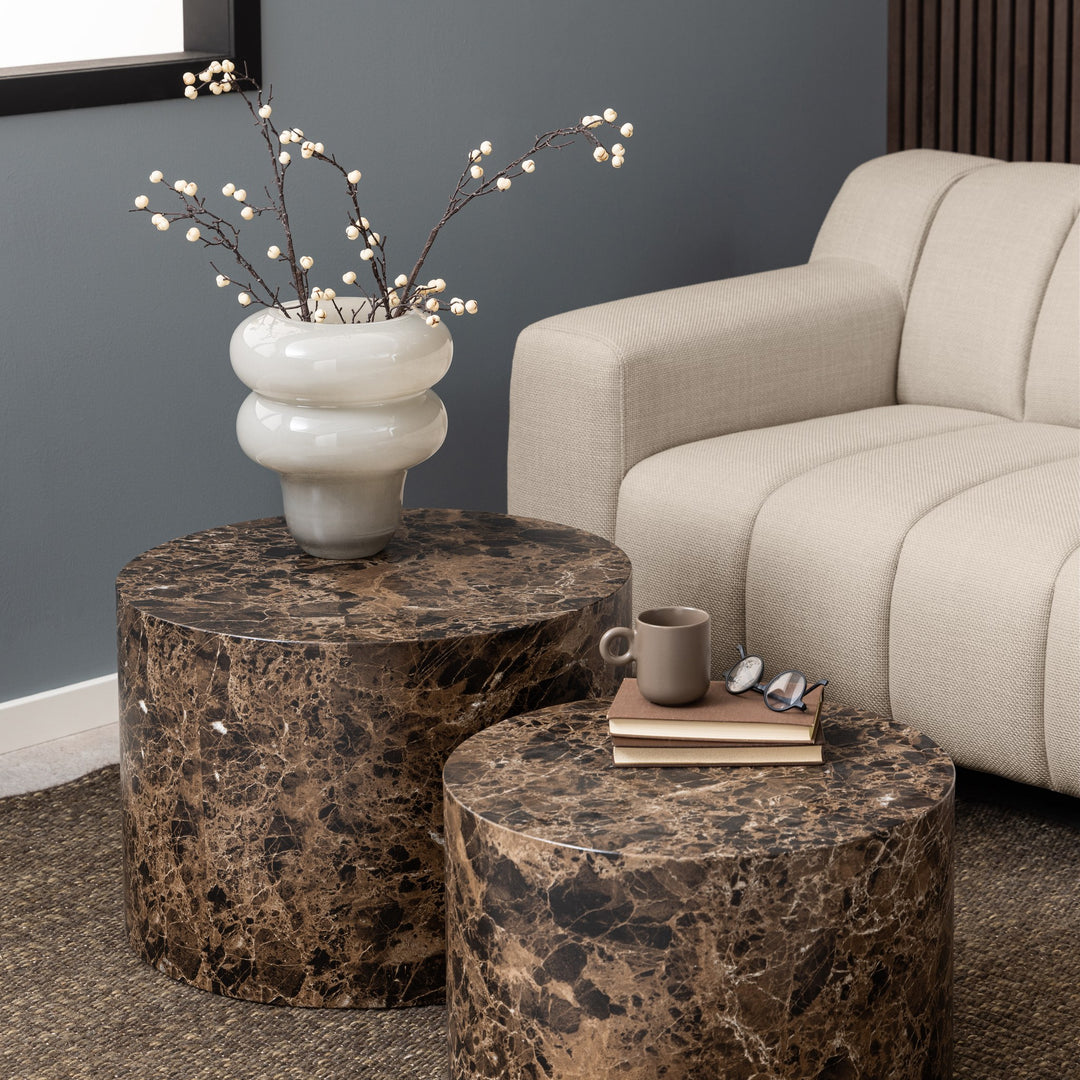 Dice sidebord i brun marmor, sett med to runde bord i stue med beige sofa og hvit vase med kvister