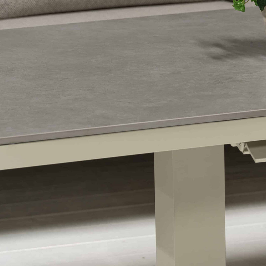 Orlando sofabord med grå keramikkplate og kremfarget ramme ved beige sofa, nærbilde