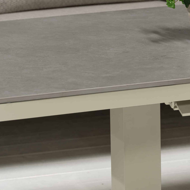 Orlando sofabord med grå keramikkplate og kremfarget ramme ved beige sofa, nærbilde